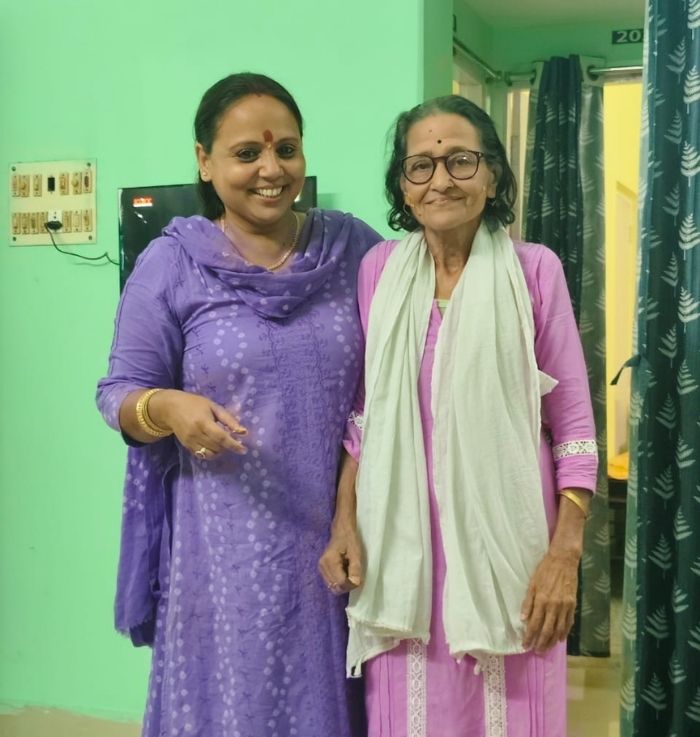 Caregiver supporting a senior resident at Ananda Niketan